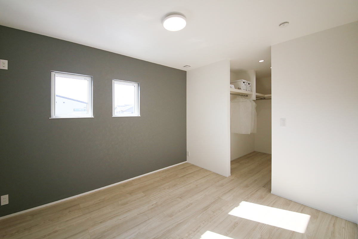 寝室は濃いグレーのアクセントクロスを使用し落ち着いた空間に。